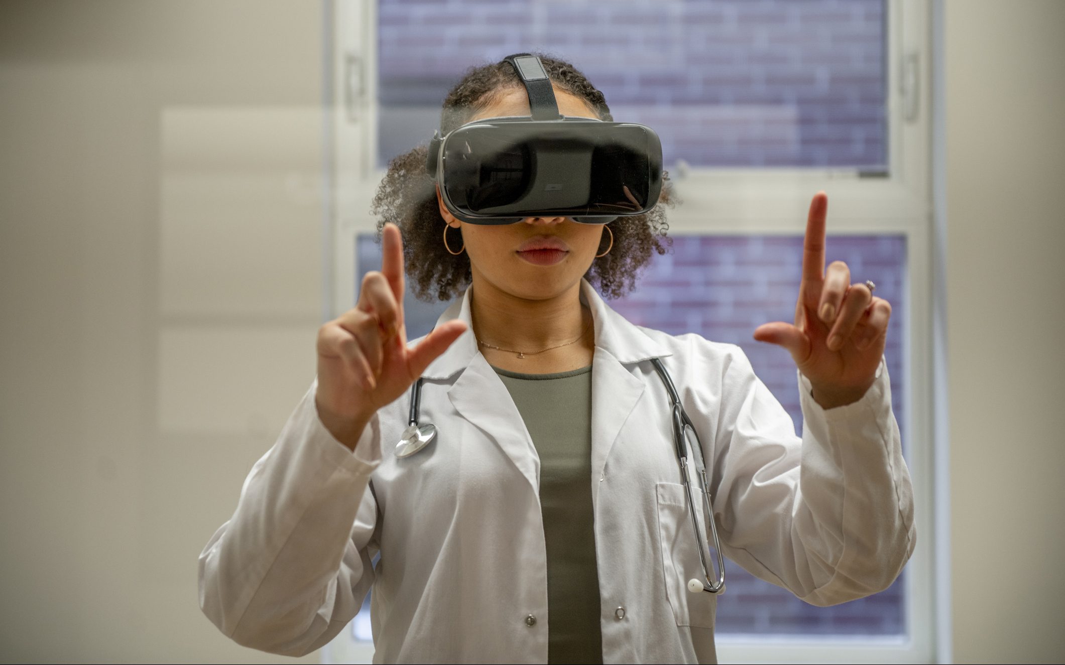 Female medical professional using a virtual reality headset in a clinic to explore a medical case for educational purposes.